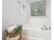Bright white soaking tub with a window view and a neutral-toned tile floor at 651 Coligny Ct, Atlanta, GA 30350