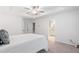 This primary bedroom boasts a tray ceiling, ceiling fan, carpet flooring and adjacent bath at 651 Coligny Ct, Atlanta, GA 30350