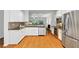 This spacious kitchen has stainless appliances, white cabinets, and granite countertops that open to the living room at 651 Coligny Ct, Atlanta, GA 30350