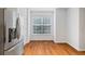 Bright eat-in kitchen area with wood floors features a stainless steel refrigerator and large window with a view at 651 Coligny Ct, Atlanta, GA 30350