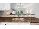 A kitchen with stainless steel double sink, dark countertops, light backsplash, and an adjacent view of the living room at 651 Coligny Ct, Atlanta, GA 30350