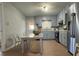 Eat-in kitchen featuring wood-look floors, stainless steel appliances, grey cabinetry, and lots of natural light at 303 Latimer Se St, Marietta, GA 30008