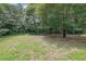 This expansive backyard features lush trees, a lawn and a playset for outdoor enjoyment and relaxation at 3181 Woodbridge Ct, Snellville, GA 30039