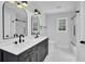 Modern bathroom features double vanity with black fixtures, white tile, and sleek lighting at 3181 Woodbridge Ct, Snellville, GA 30039