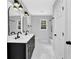 Modern bathroom features double vanity with black fixtures, white tile, and sleek lighting at 3181 Woodbridge Ct, Snellville, GA 30039