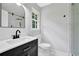 Bathroom featuring sleek black vanity, modern fixtures, white marble floors, glass shower and natural light at 3181 Woodbridge Ct, Snellville, GA 30039