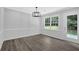 Dining room featuring wood floor, a large window, stylish lighting, and neutral paint at 3181 Woodbridge Ct, Snellville, GA 30039