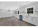 Bright kitchen features white cabinets, stainless steel appliances, and new wood flooring at 3181 Woodbridge Ct, Snellville, GA 30039