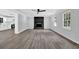 Bright living room featuring modern gray flooring, a black painted fireplace, and updated fixtures at 3181 Woodbridge Ct, Snellville, GA 30039