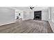 Living room showcasing gray flooring, a dark fireplace, and an open layout connected to the kitchen at 3181 Woodbridge Ct, Snellville, GA 30039