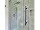 This modern shower has sleek fixtures, a glass door, and luxurious white tile for a spa-like experience at 3181 Woodbridge Ct, Snellville, GA 30039