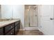 A bathroom featuring granite counters, a white sink, dark wood cabinets, and a glass door shower at 382 Mulberry Se Row, Atlanta, GA 30354