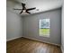 Bedroom features hardwood flooring, ceiling fan, neutral paint and a window with blinds at 5445 Eva Mamie Ln, Stone Mountain, GA 30083