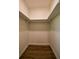Walk-in closet with luxury vinyl plank flooring and ample shelving for optimal storage at 5445 Eva Mamie Ln, Stone Mountain, GA 30083
