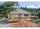 Home with a gray roof, cream siding, wood deck, gravel landscaping and a car at 5445 Eva Mamie Ln, Stone Mountain, GA 30083
