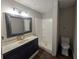 Bathroom with a dark vanity, framed mirror, shower, and toilet at 446 Westbrook Rd, Carrollton, GA 30116