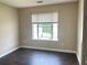 Comfortable bedroom featuring dark hardwood floors, neutral walls, and a well-lit window at 5465 Twin Lakes Dr, College Park, GA 30349