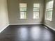 Spacious living room with three windows and wood flooring at 5465 Twin Lakes Dr, College Park, GA 30349