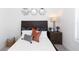 This bedroom features a dark wood headboard, hexagon mirrors, and a coordinated nightstand with lamp at 621 Silva St # 124, Cumming, GA 30040