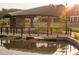 A charming bridge over a calm pond, with modern architecture and lush landscaping in the background at 621 Silva St # 124, Cumming, GA 30040