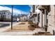 View of street lined with attractive townhomes with lush greenery and inviting front steps at 621 Silva St # 124, Cumming, GA 30040