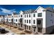Row of new townhomes with brick accents, gray roof and trimmed green lawns, showcasing street appeal at 621 Silva St # 124, Cumming, GA 30040
