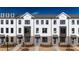 Attractive new construction townhomes with white exteriors, contrasting brick, and manicured front lawns at 621 Silva St # 124, Cumming, GA 30040