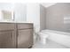 Modern bathroom features gray subway tile, neutral vanity, and tub with shower at 629 Silva St # 128, Cumming, GA 30040