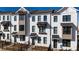 Townhome exterior featuring a painted brick facade, contrasting window trim, and manicured lawn at 629 Silva St # 128, Cumming, GA 30040