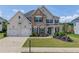 Beautiful two-story home with a well-manicured lawn, stone accents, and a three-car garage at 4035 Starwood Dr, Cumming, GA 30028