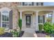 Charming front porch with stone accents, white columns, and a decorative glass front door at 4035 Starwood Dr, Cumming, GA 30028