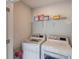 Bright laundry room featuring a stacked washer and dryer and a shelf for storage of supplies at 4035 Starwood Dr, Cumming, GA 30028