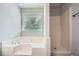 Bathroom featuring a soaking tub, separate shower, and a bright window with natural light at 520 White Pines Dr, Dallas, GA 30157