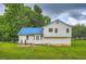 Rear exterior view of home with white siding, a blue metal roof, and a spacious yard at 520 White Pines Dr, Dallas, GA 30157