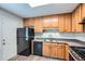 This kitchen is equipped with black appliances, wooden cabinets, and neutral countertops at 520 White Pines Dr, Dallas, GA 30157
