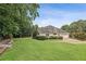 Beautiful backyard with lush green grass, mature trees, and a playset, perfect for Gathering fun and relaxation at 5349 Forest Springs Dr, Dunwoody, GA 30338