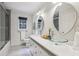 Bright bathroom featuring a double vanity with modern glass vessel sinks, sleek fixtures, and a tiled shower at 5349 Forest Springs Dr, Dunwoody, GA 30338