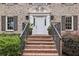 Elegant brick stairs leading to a front door with decorative molding, planters, and stylish sconces at 5349 Forest Springs Dr, Dunwoody, GA 30338