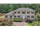 Traditional brick home featuring a manicured lawn, brick driveway, shutters, and a welcoming front door at 5349 Forest Springs Dr, Dunwoody, GA 30338
