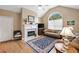 Cozy living room featuring a fireplace, vaulted ceiling, and large arched window at 6355 Autumn View Nw Pt, Acworth, GA 30101