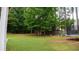 Spacious backyard featuring lush greenery, privacy fence, trampoline and garden beds at 1332 Chandler Cove Way, Grayson, GA 30017