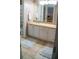 Bright bathroom featuring dual sinks, white cabinetry, and a large mirror at 1332 Chandler Cove Way, Grayson, GA 30017