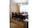 A dining area with seating for six, features a modern chandelier and a window covered with sheer curtains at 1332 Chandler Cove Way, Grayson, GA 30017
