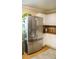 Stainless steel refrigerator in a kitchen with white cabinets and tile floors at 1332 Chandler Cove Way, Grayson, GA 30017