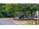 Outdoor playground with slide and climbing structure near sidewalk and lush greenery, fully fenced in for community enjoyment at 1332 Chandler Cove Way, Grayson, GA 30017