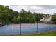 Community tennis court is fenced and ready for a match, with benches for spectators and surrounded by trees at 1332 Chandler Cove Way, Grayson, GA 30017