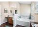 Bright bathroom featuring a soaking tub with marble surround, vanity and hardwood floors at 2512 Halcyon Way, Lawrenceville, GA 30044