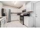 Well-lit kitchen boasts white cabinets, stainless steel appliances, and sleek countertops at 2512 Halcyon Way, Lawrenceville, GA 30044