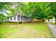 Well-maintained one-story house with screened porch, green lawn, and mature trees at 6539 E Strickland St, Douglasville, GA 30134