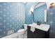 Chic powder room featuring starburst wallpaper, black vanity with white top, and modern mirror at 1017 Mill Creek Ne Mnr, Brookhaven, GA 30319